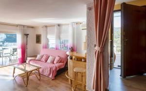 滨海托萨Xalupa Salions Vistas的客厅配有粉红色的沙发和桌子