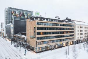 奥卢GreenStar Hotel Oulu的街道旁的大雪地建筑