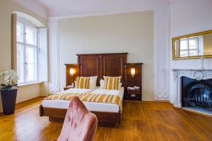 Drehna弗斯蒂申德瑞赫城堡酒店的一间卧室设有一张大床和一个壁炉
