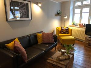 维斯马Altstadthaus TimpeTe的客厅配有真皮沙发和黄椅