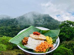 丹不拉Eco Village Kalundewa的香蕉叶上一盘带米和蔬菜的食物