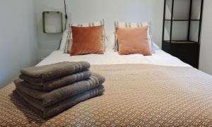 宁斯佩特Luxe Tiny House op de Veluwe的床上有一堆毛巾