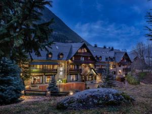 特雷多斯Hotel de Tredós Baqueira, Affiliated by Meliá的一座大房子,背景是一座山