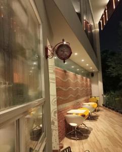 达卡Empyrean Dhaka City Centre的墙上有桌子和时钟的餐厅