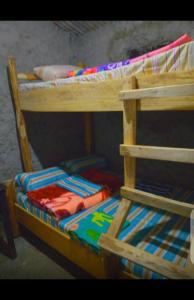 KapchorwaSunrise homestay Sipi的一张木制双层床,上面有五颜六色的被子