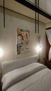普拉托Appartamento Torre della Buca的卧室配有白色的床和灯