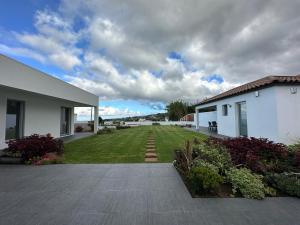 NordestinhoSerenity Azores - Casa da Aldeia的一座带绿色庭院的房屋的后院