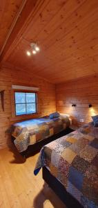 ÞórshöfnFálki cottages的小木屋内一间卧室,配有两张床