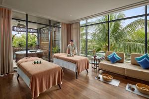 富国Best Western Premier Sonasea Villas Phu Quoc的站在酒店房间,带两张床的男人