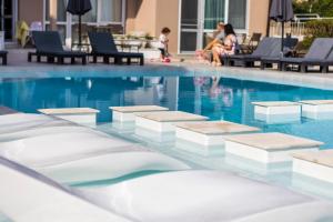索佐波尔Selena Beach Family Hotel - All Inclusive Light的游泳池旁边有人坐在椅子上