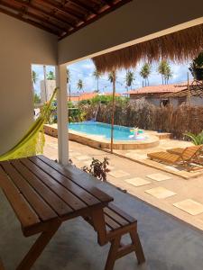 皮廷布Pousada Vila Lua Bela的一个带木凳和游泳池的庭院