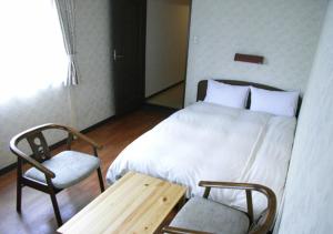 大阪太阳广场临海酒店的卧室配有1张床、1张桌子和1把椅子