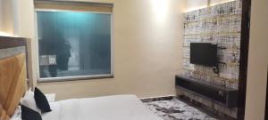 Pura RaghunāthHotel K J International的一间酒店客房,配有一张床和一台电视