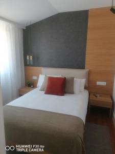 里斯本Timeless - Energy - Belém的卧室配有一张大白色床和红色枕头