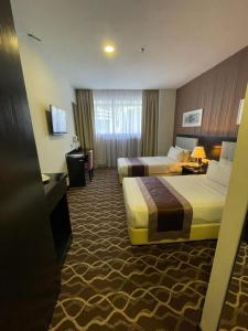 吉隆坡吉隆坡格兰德坎贝尔酒店的酒店客房设有两张床和电视。