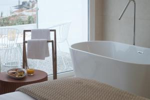 穆罗斯Otantus Hotel的带浴缸的浴室和阳台