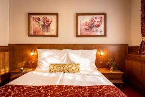 瓦拉什斯凯梅济日奇埃伯基康体酒店的卧室配有一张床,墙上挂有两张照片