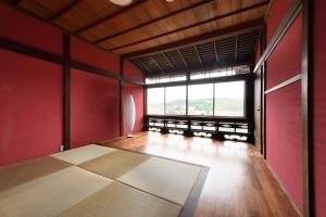 金泽UFU Kanazawa的一间空房间,设有红色的墙壁和大窗户
