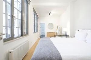 布鲁塞尔Appartement design 3 chambres proximité Grand-Place Bruxelles的白色卧室设有大床和窗户