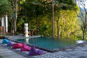 姆杜克Puri Sunny Guesthouse的游泳池周围设有色彩缤纷的枕头