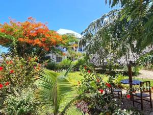 南威Frangipani House Nungwi Zanzibar的花园配有桌椅和鲜花