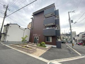京都HOTEL KANSO - Vacation STAY 88798的棕色的建筑,旁边设有楼梯