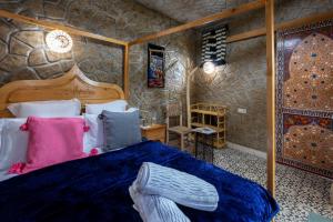 舍夫沙万Riad Mosaic的一间卧室设有一张床和石墙