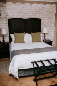 威特班克La Bendicion的一张大床,配有黑色床头板和两盏灯