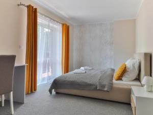 姆拉哥沃Go Mazury的一间卧室配有床和橙色窗帘的窗户