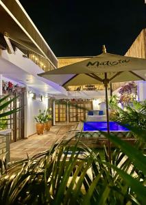 瓜杜阿斯Matisia Hotel Boutique的庭院在晚上配有雨伞和植物