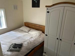 BalbyAngie’s hideaway的卧室配有白色床、橱柜和床。