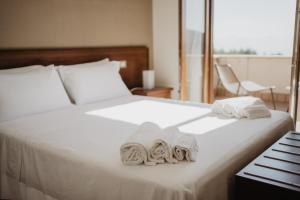 圣焦万尼亚皮罗特努塔特里博斯克酒店的一间卧室配有带毛巾的床