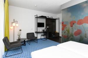 奈凯尔克小红屋酒店的酒店客房,配有一张床和两把椅子