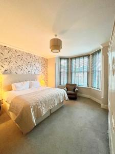 莱瑟姆-圣安妮Mode Apartments St Annes的一间卧室配有一张床、一把椅子和窗户。
