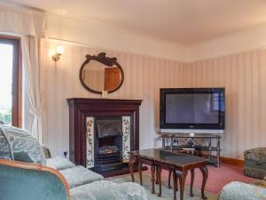 ScalfordGlossoms Lodge的客厅设有壁炉和电视。