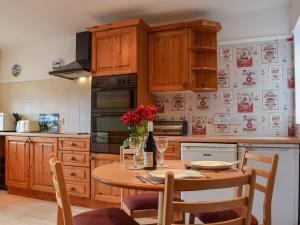 ScalfordGlossoms Lodge的厨房配有带红色鲜花的木桌