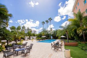 圣地亚哥洛斯卡巴霍德帕花园酒店的一个带椅子的庭院、一个游泳池和棕榈树