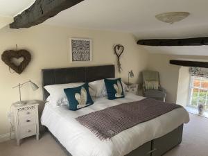 WarcopThe Cosy Nook Cottage Company - Cosy Cottage的一间卧室配有一张带蓝色枕头的大床