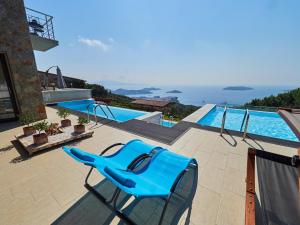 斯基亚索斯镇Sky Sea Resort Skiathos的游泳池旁天井上的蓝色椅子