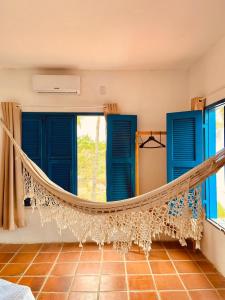 拉戈伊尼亚Montepascual Ecovillage的带蓝色窗户的客房内的吊床