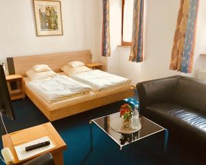 埃伦茨-波尔特斯多夫文古德润酒店的客房设有床、沙发和桌子。