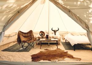 Margouët-MeymèsCamping d'artagnan的带帐篷、床和桌子的客房