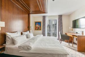 慕尼黑AdvaStay by KING's的酒店客房设有一张大床和一张书桌。