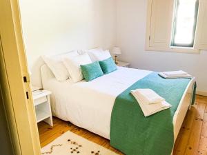雷森迪Quintinha de Pinouco的卧室配有带蓝色枕头的大型白色床