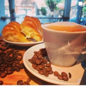 贝纳多图埃托Apart hotel Magda的一杯咖啡和一盘咖啡豆