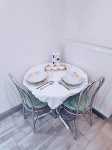 波普拉德Vila Safin的一张带椅子和盘子的白色桌子