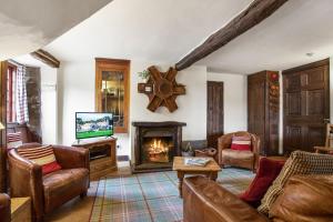 科尼斯顿The Mountain Cottages - Carpenters的客厅设有壁炉和电视。