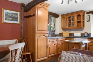 科尼斯顿The Mountain Cottages - Carpenters的厨房配有木制橱柜和桌子