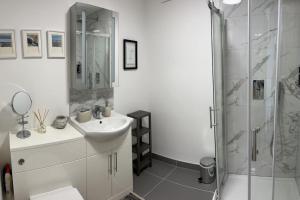 利克No5 at 53 - 2 bed apartment in Leek, Staffs Peak District的白色的浴室设有水槽和淋浴。