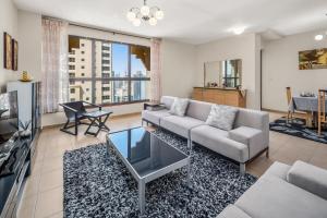 迪拜Lovely 2-bed condo in JBR - 5 mins from beach - Palm View!的带沙发和电视的客厅